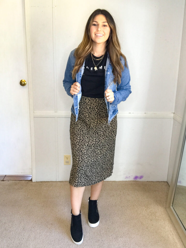 a jean jacket styled with a midi skirt and graphic shirt