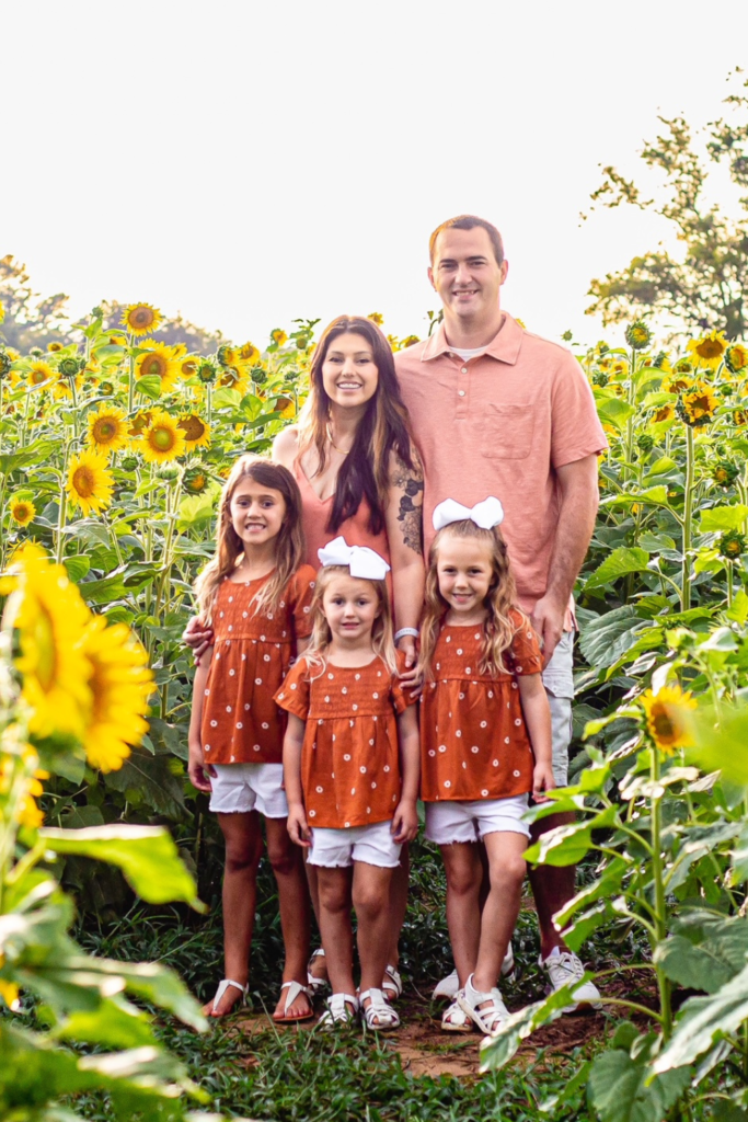 family photo in a sunflower field wearing the color burnt orange 