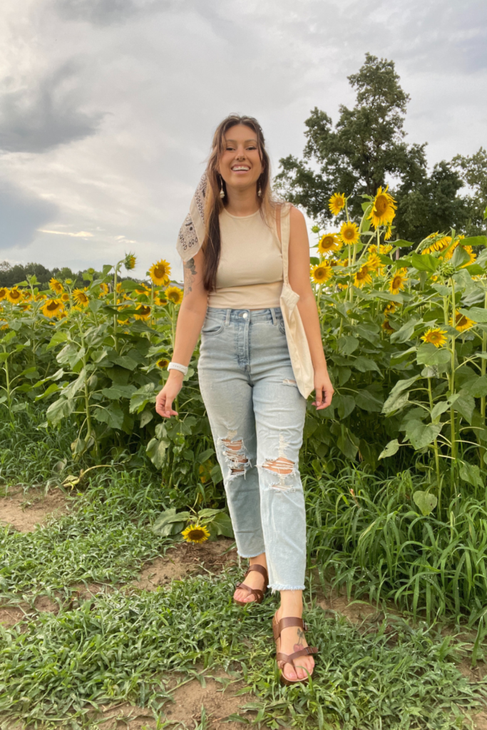 sunflower field  picture outfit with a beige tank top, straight leg jeans and brown sandals